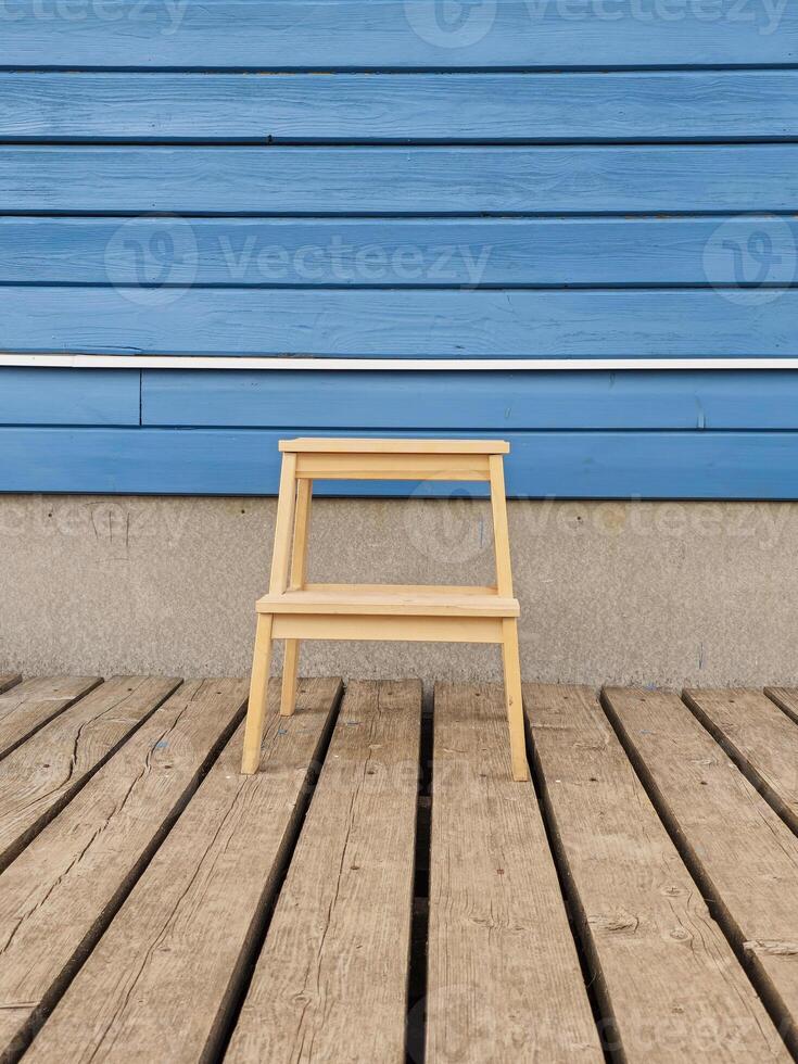 Ladder stool against a blue wooden home wall photo
