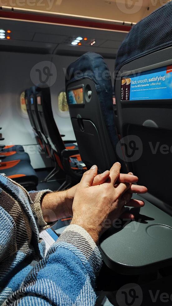 Empty airplane cabin. a Male hands on the table in the airplane cabin during landing photo