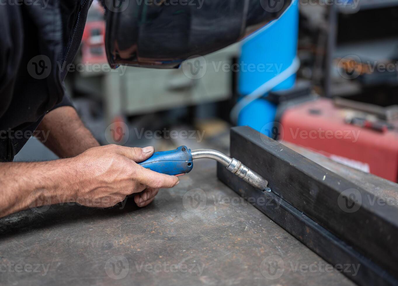 A man is welding a piece of metal photo