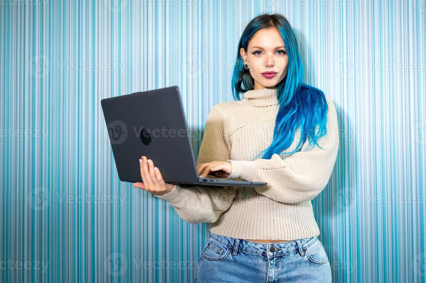 A woman with blue hair holding a laptop photo