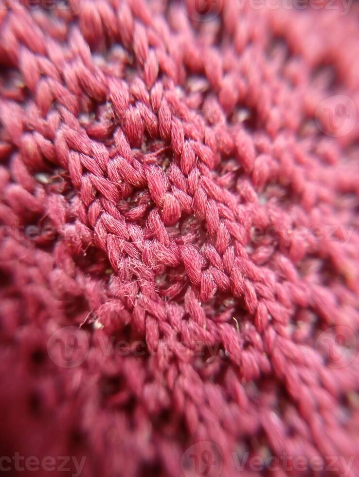 Close-Up of Red Knitted Fabric. A highly detailed close-up of red knitted fabric, revealing the texture and fiber strands. photo