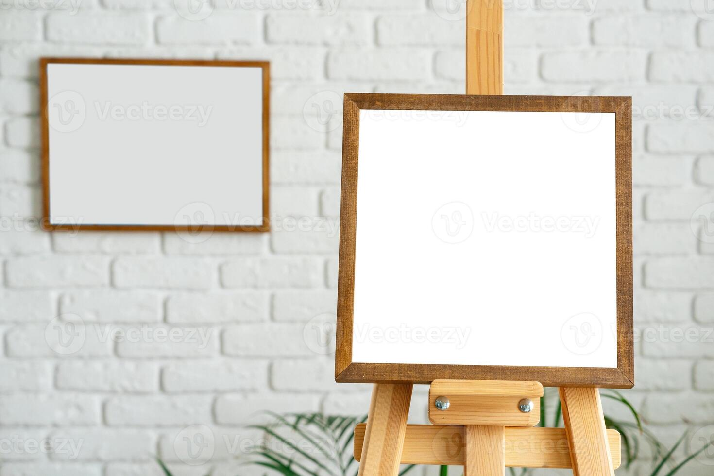 Blank canvas on wooden easel in modern art studio with white brick walls and minimalistic decor photo