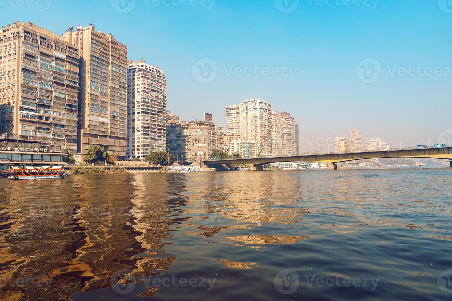 Skyline of Cairo along the Nile River during clear skies reflecting vibrant colors and modern architecture photo