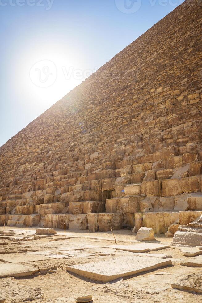Exploring the grandeur of the Great Pyramid of Giza under the midday sun during a clear day photo