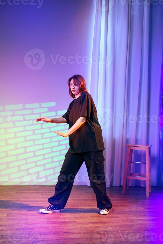 Dancer performs contemporary style in a colorful studio setting during a dance rehearsal photo