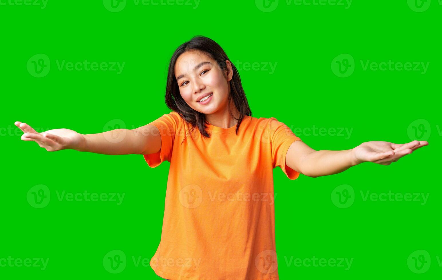 Young woman with outstretched arms welcomes positivity against a bright green background photo