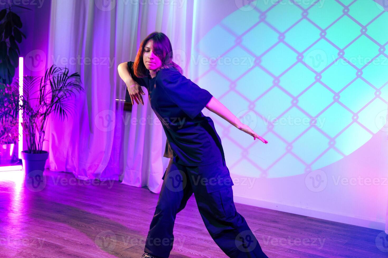 Dance performance showcases expressive movement under colorful lights in a modern venue photo