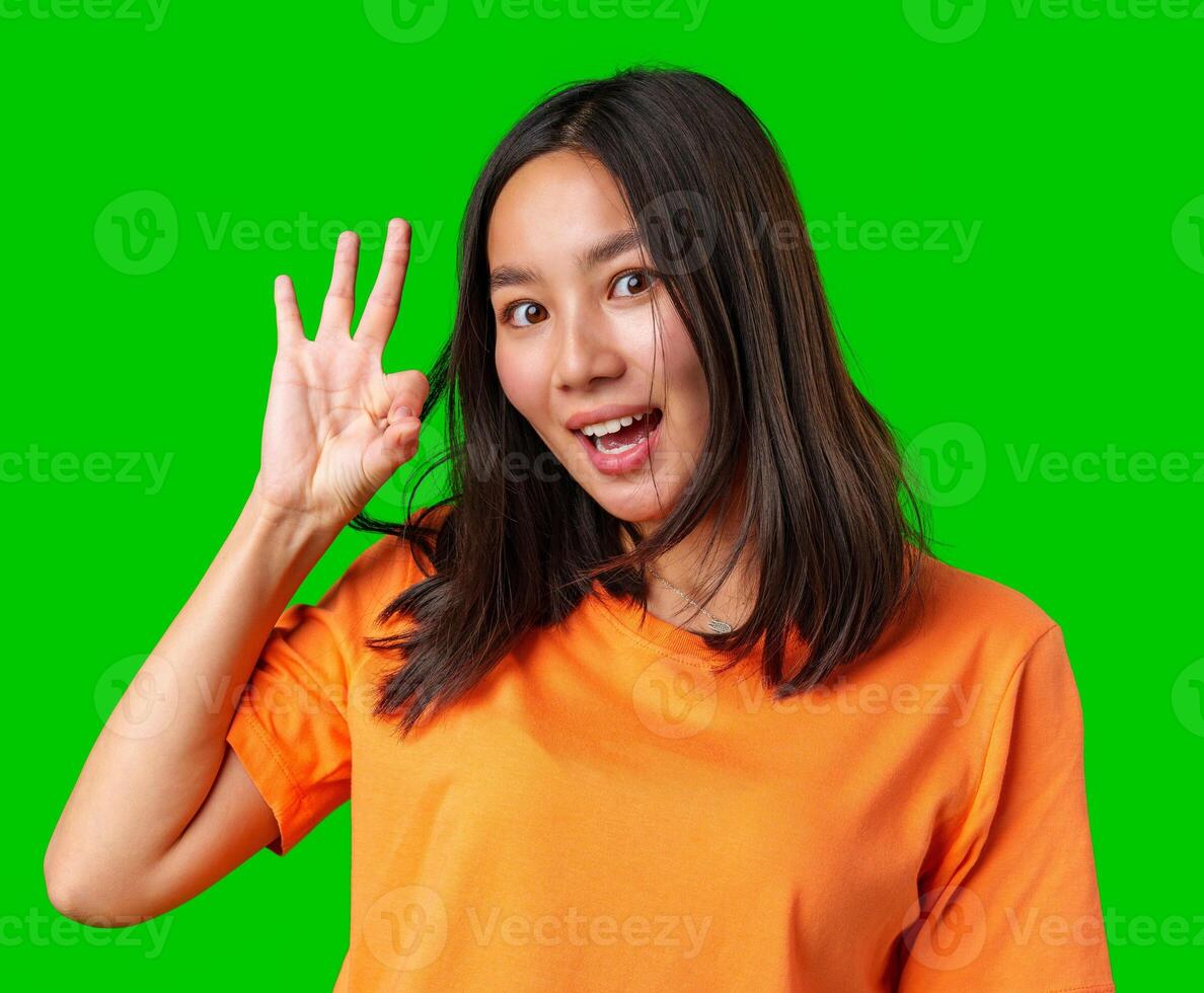 Young woman shows four fingers with a cheerful expression against a bright green background photo