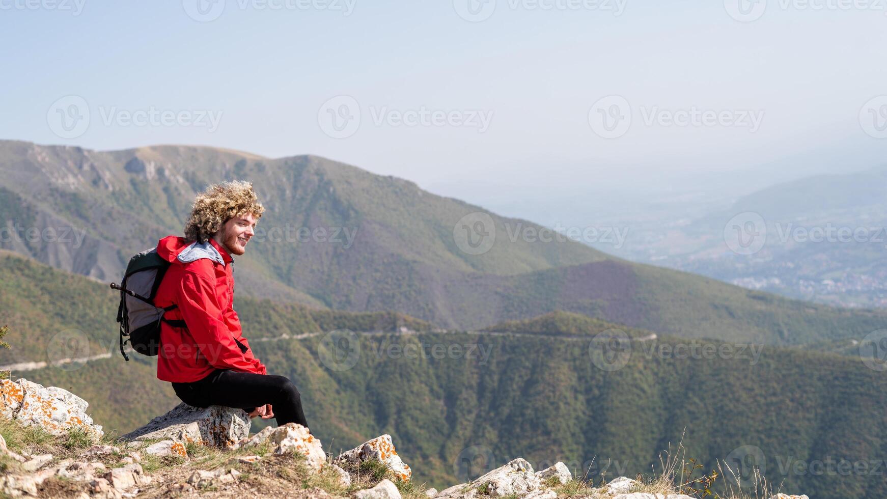 A man who hikers enjoys a break look at the mountain top, active healthy lifestyle, adventure travel. photo