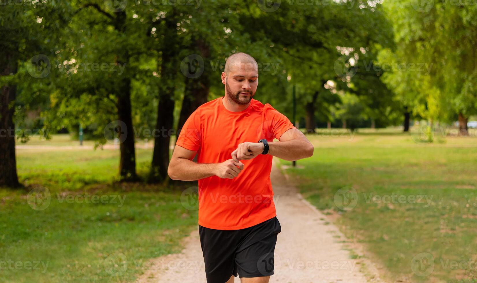 Sporty man running or jogging at the park active healthy lifestyle runner with fitness smart watch check running time. photo