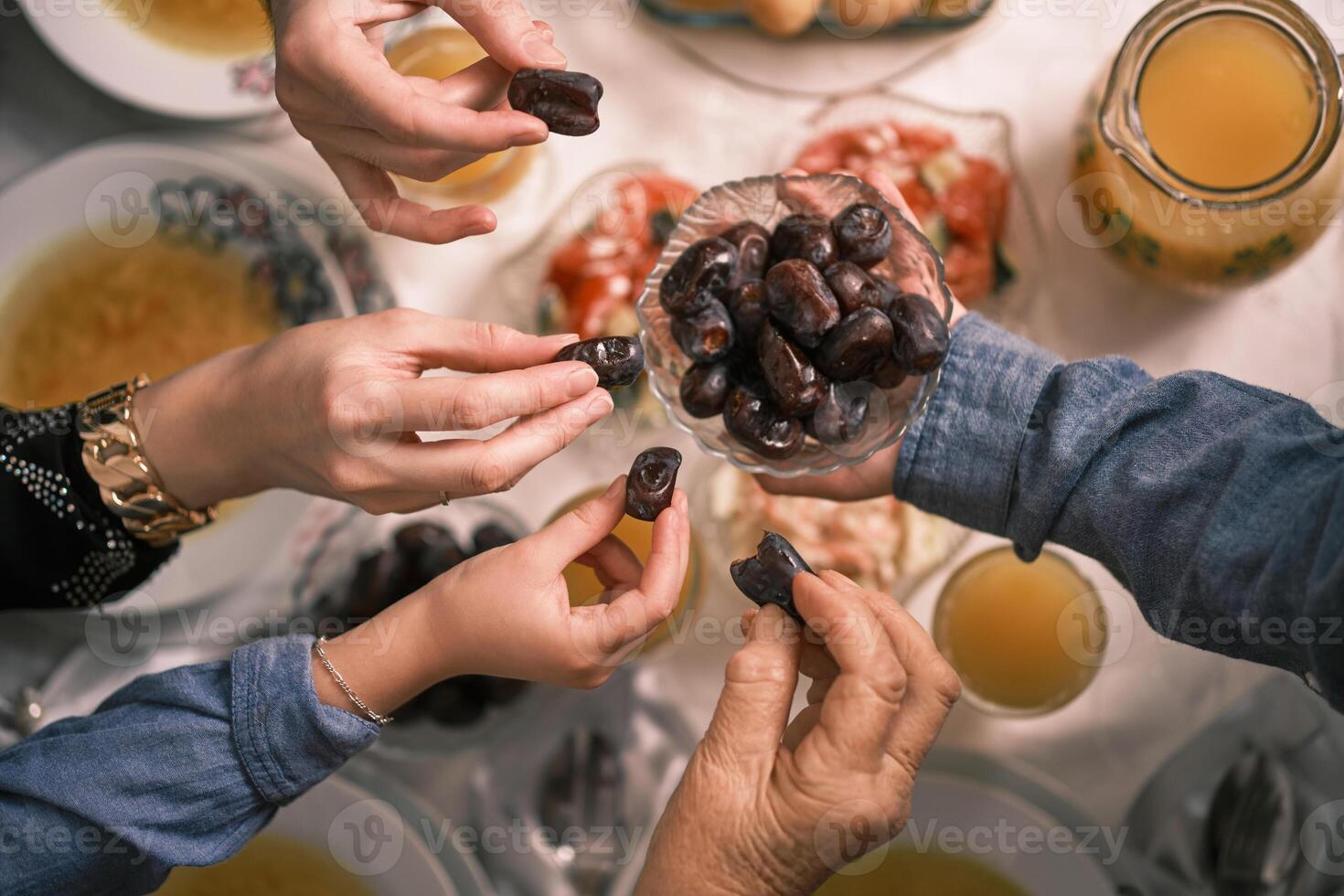 Happy Muslim family having iftar dinner to break fasting during Ramadan dining table at home or restaurant. photo
