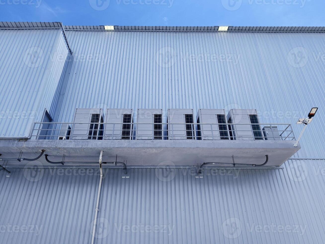 There are numerous air conditioners installed on the exterior of the building photo