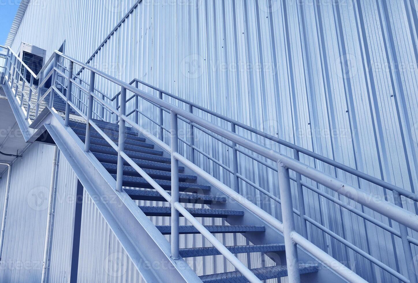 A set of stairs ascending a large blue wall photo