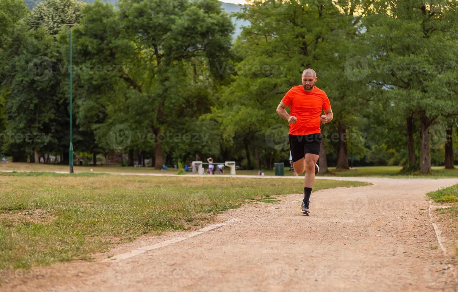 Sporty man running or jogging at the park. photo