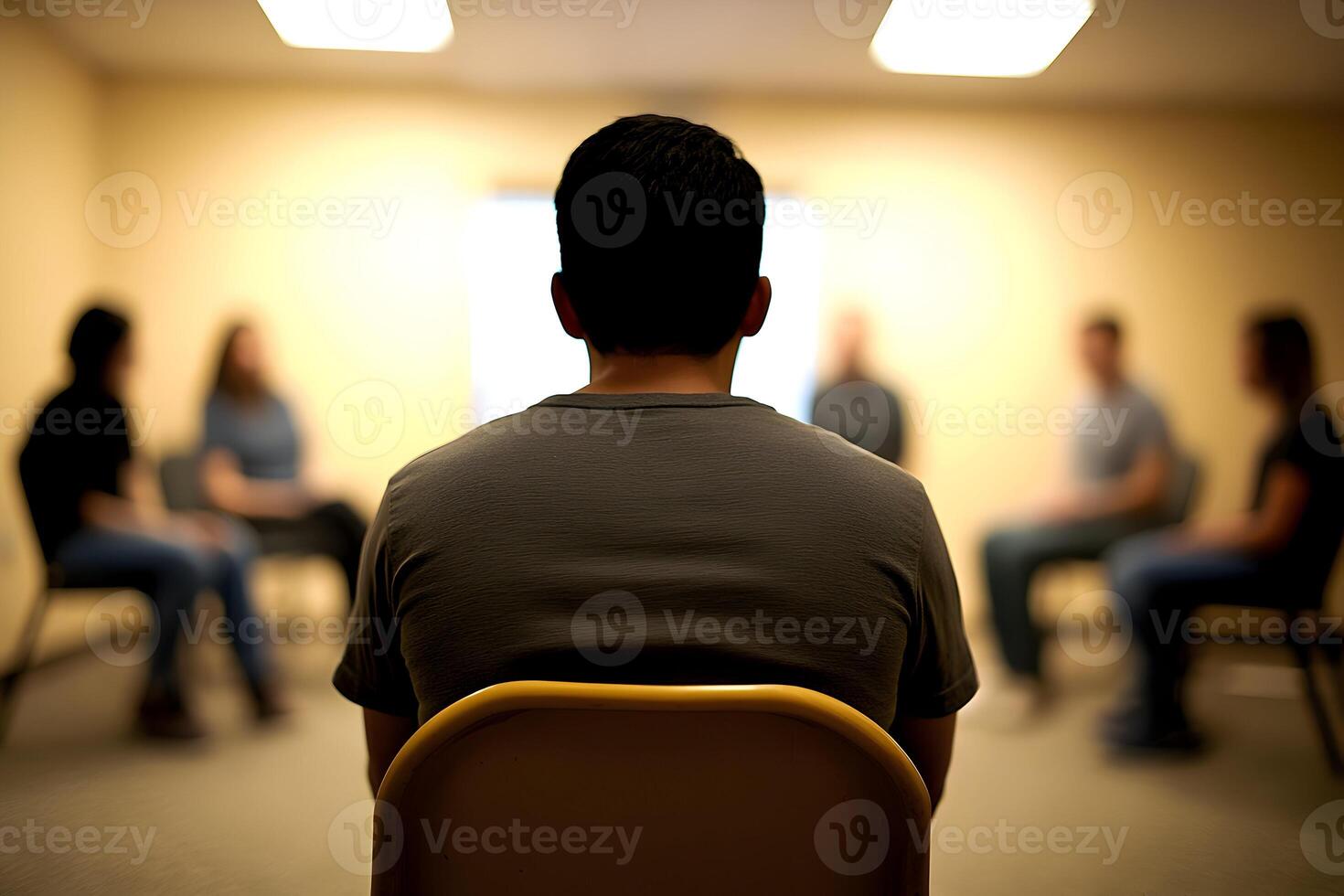 A man sitting in a chair in front of a group of people photo