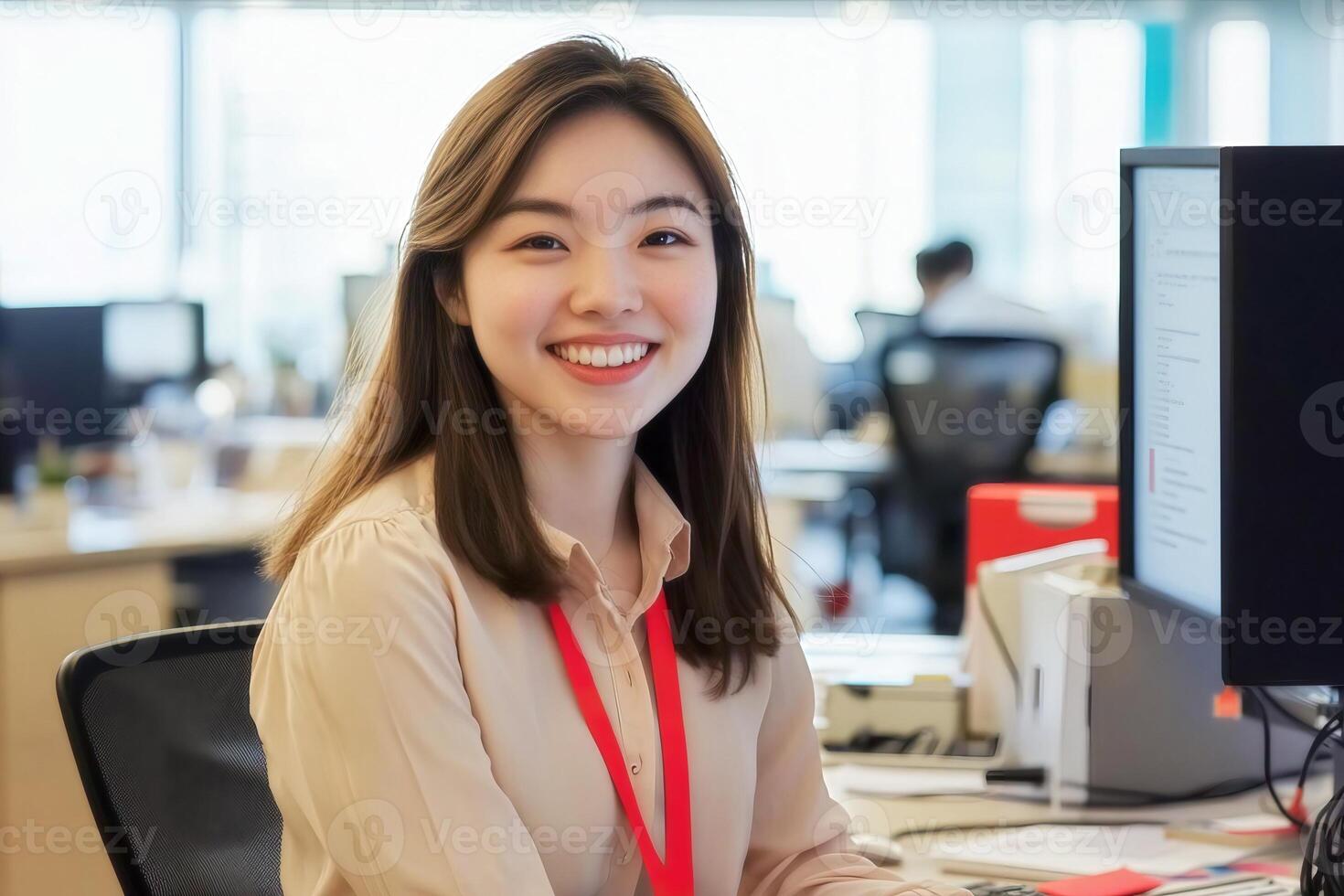 Portrait of a smiling asian woman working at her desk in a modern office environment setting indoors photo