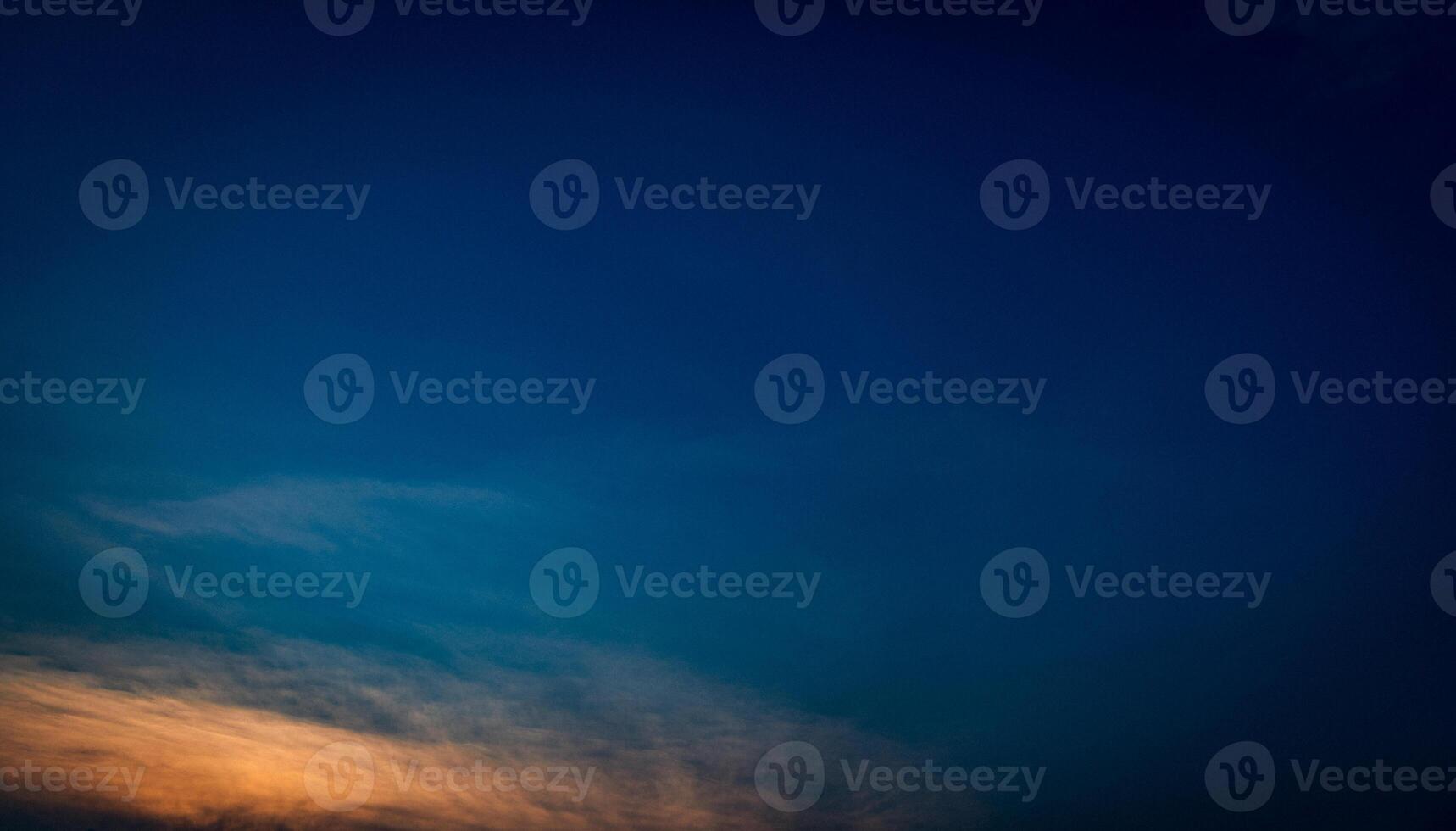 Deep blue sky with soft - hazy clouds at sunset photo