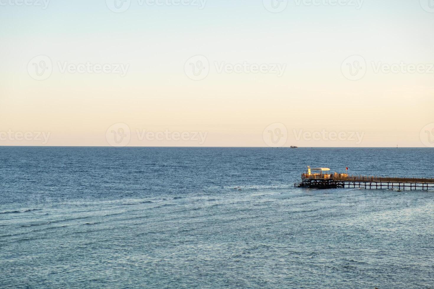 Calm waters and serene horizon at a waterfront pier in Egypt during early evening hours photo