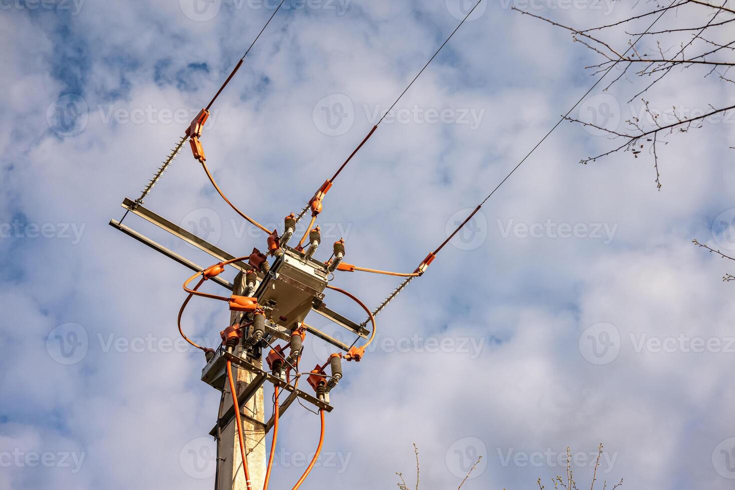 electrical pole with transformer and wires power line equipment against cloudy sky photo