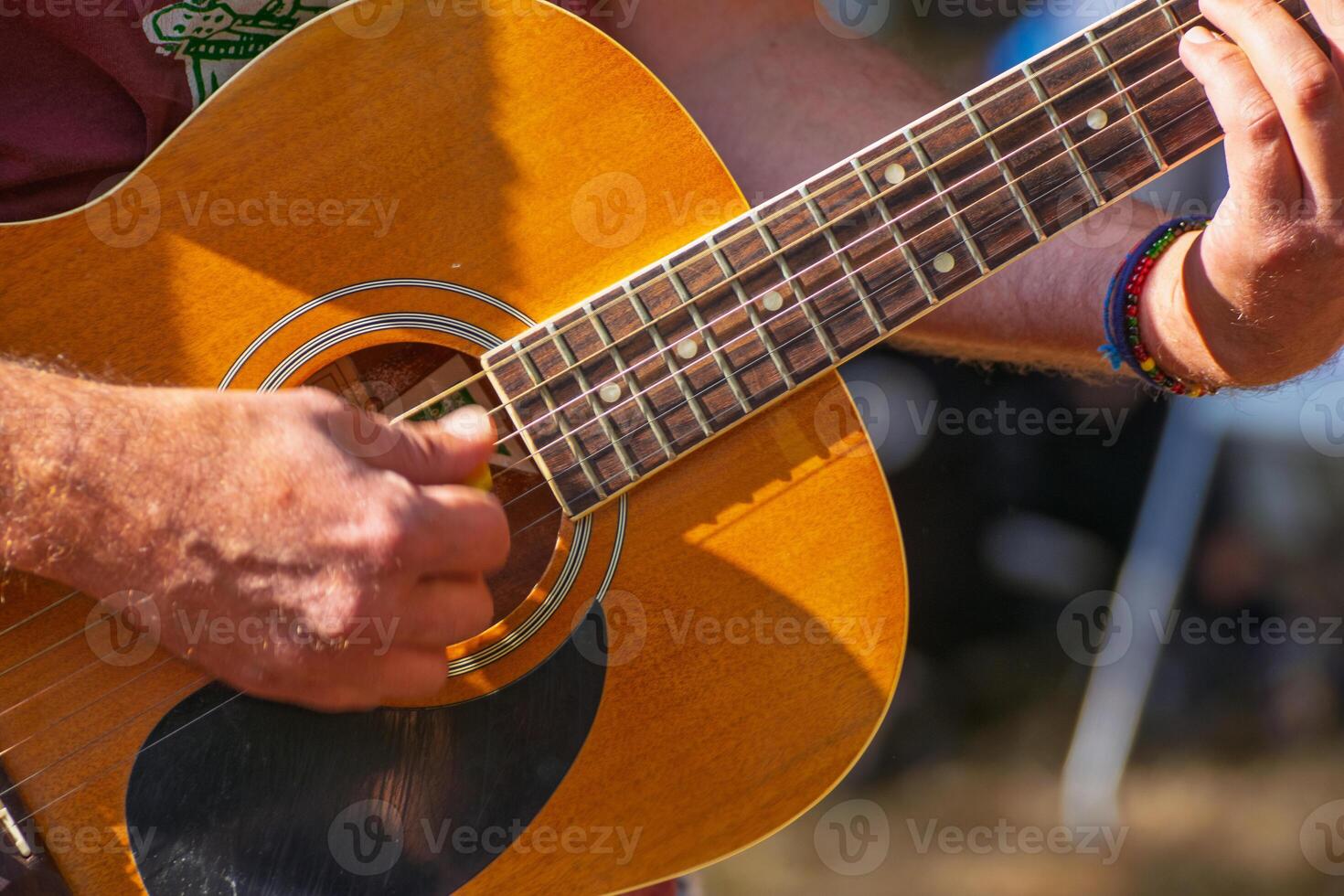 Musician playing chords on acoustic guitar strings photo