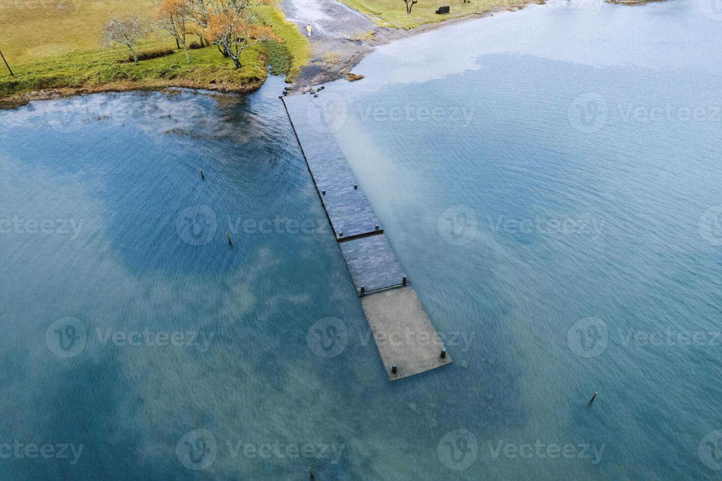 jetty on the shore of lagoa das sete cidades on a cloudy day. Sao Miguel Island, Azores. Portugal. Aerial drone view photo