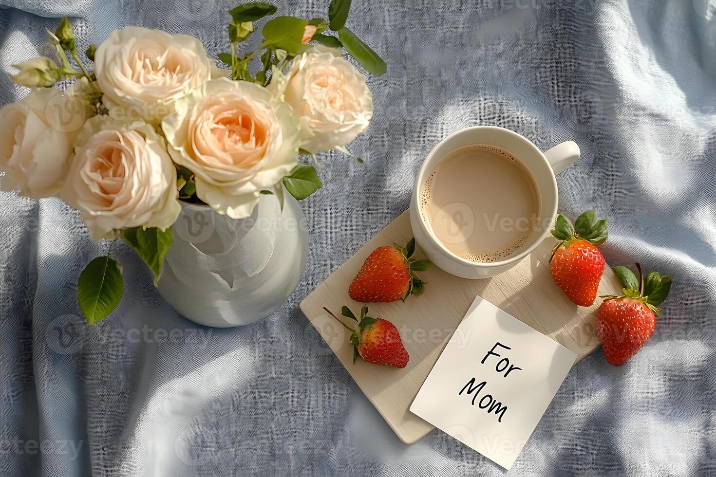 Elegant Mother's Day gift arrangement with flowers, coffee, and a handwritten card on a linen tablecloth photo