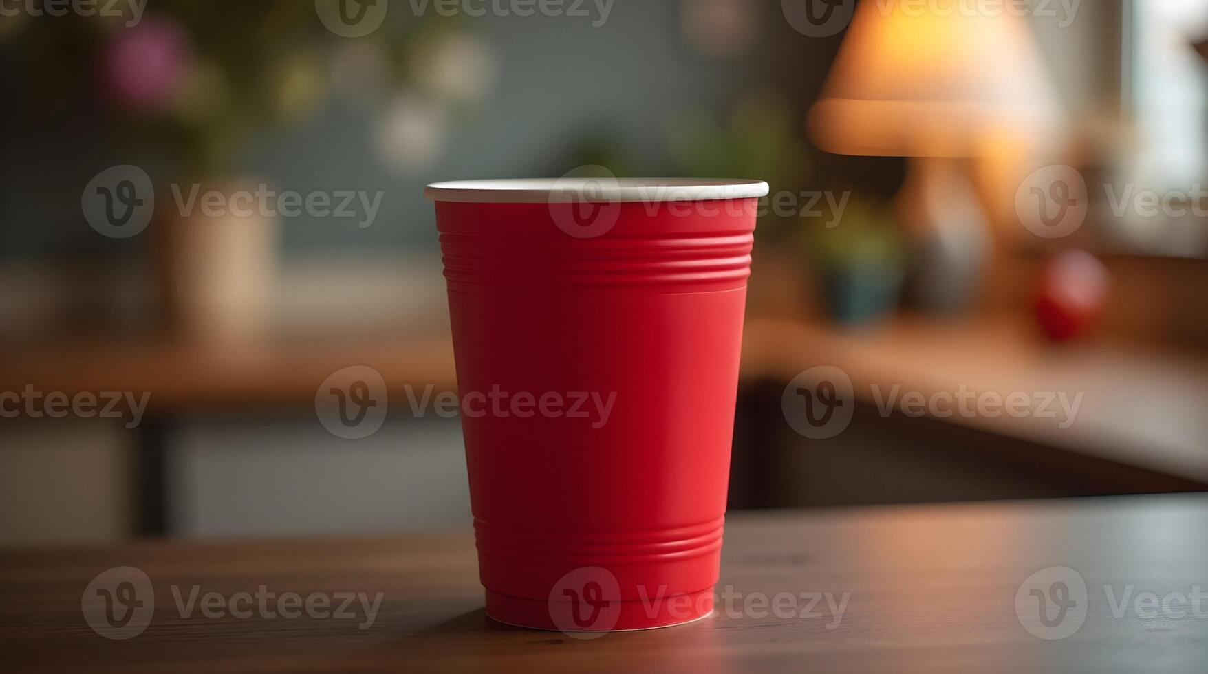 red plastic cup with a white rim stands on a wooden table against a blurred background, showcasing a simple, everyday object photo
