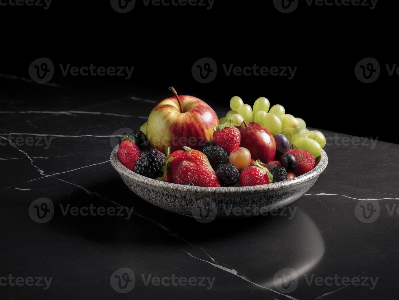 bowl of mixed fruit including apples, strawberries, grapes, and blackberries on black marble surface, creating vibrant and fresh display photo