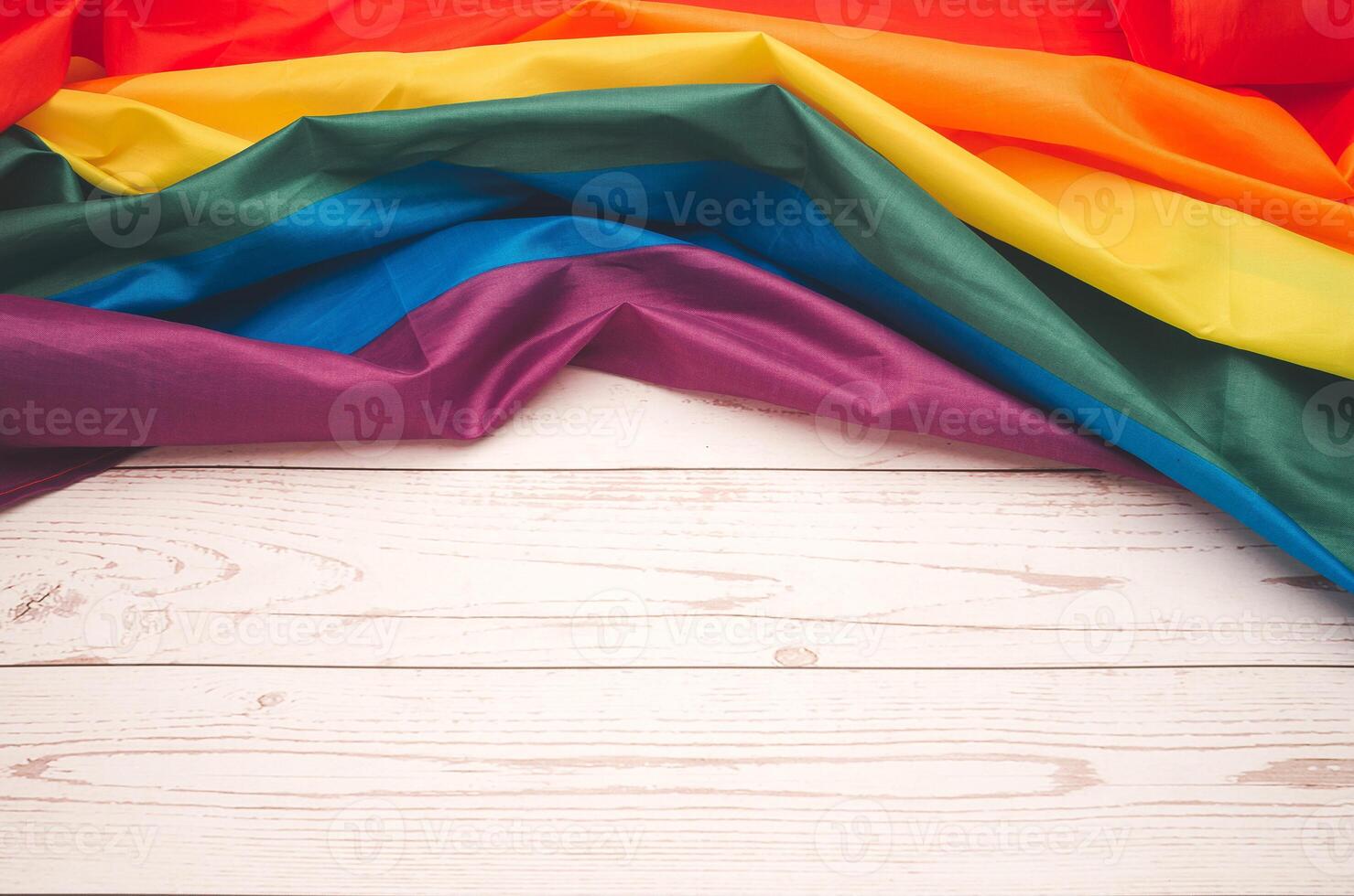 Top view of the rainbow flag or LGBTQ flag on a wooden table. photo