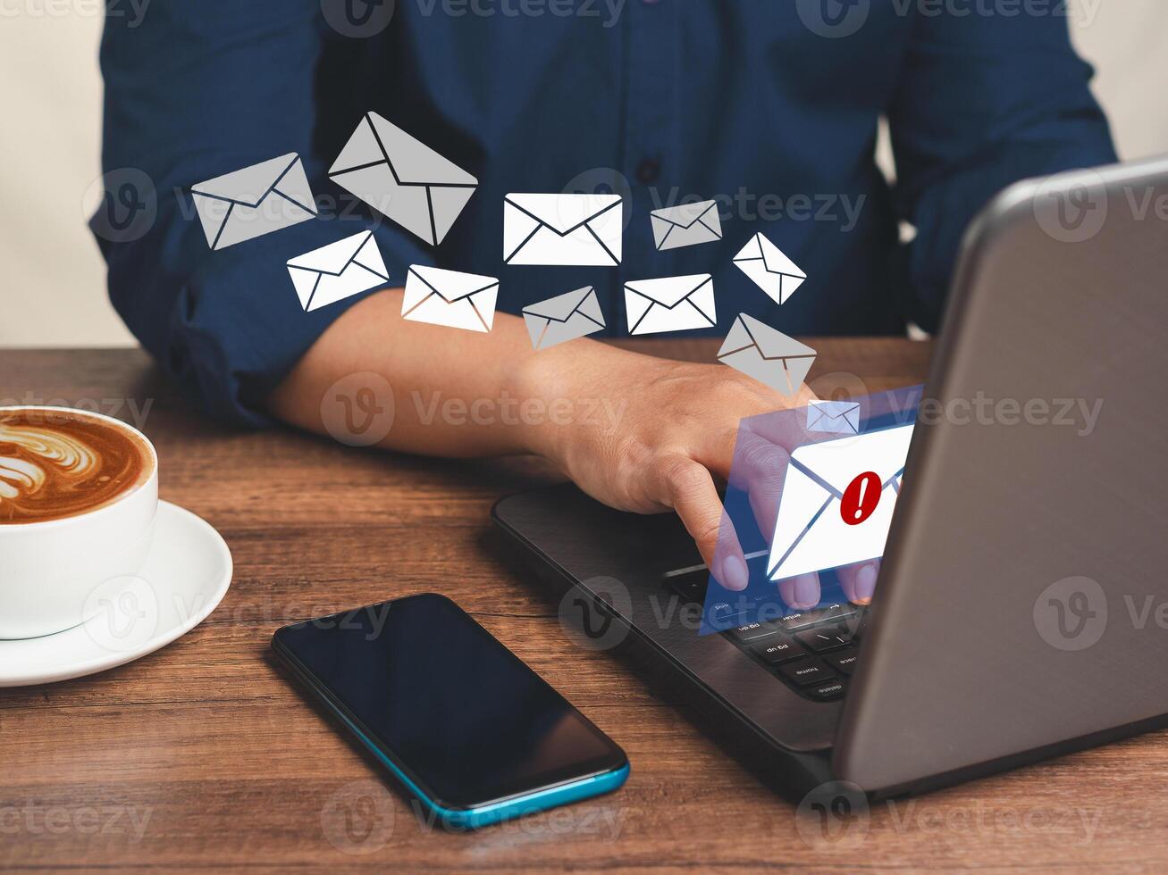 Businessman using a laptop receives a new message with email icons while sitting at the table. photo