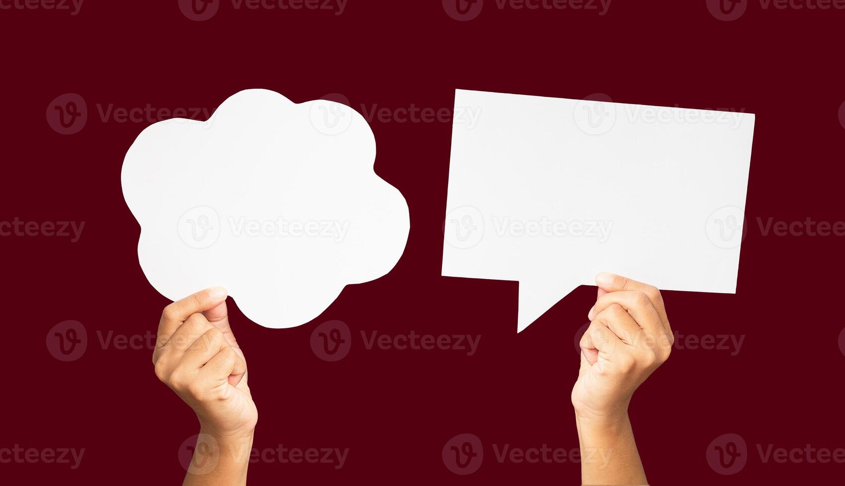 Close-up of hands holding a white speech bubbles against a red background photo