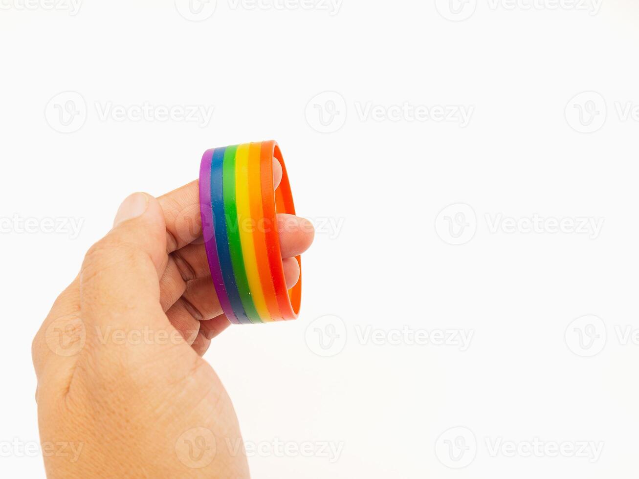 Hand holding of a rainbow wristband on a white background. Space for text. photo