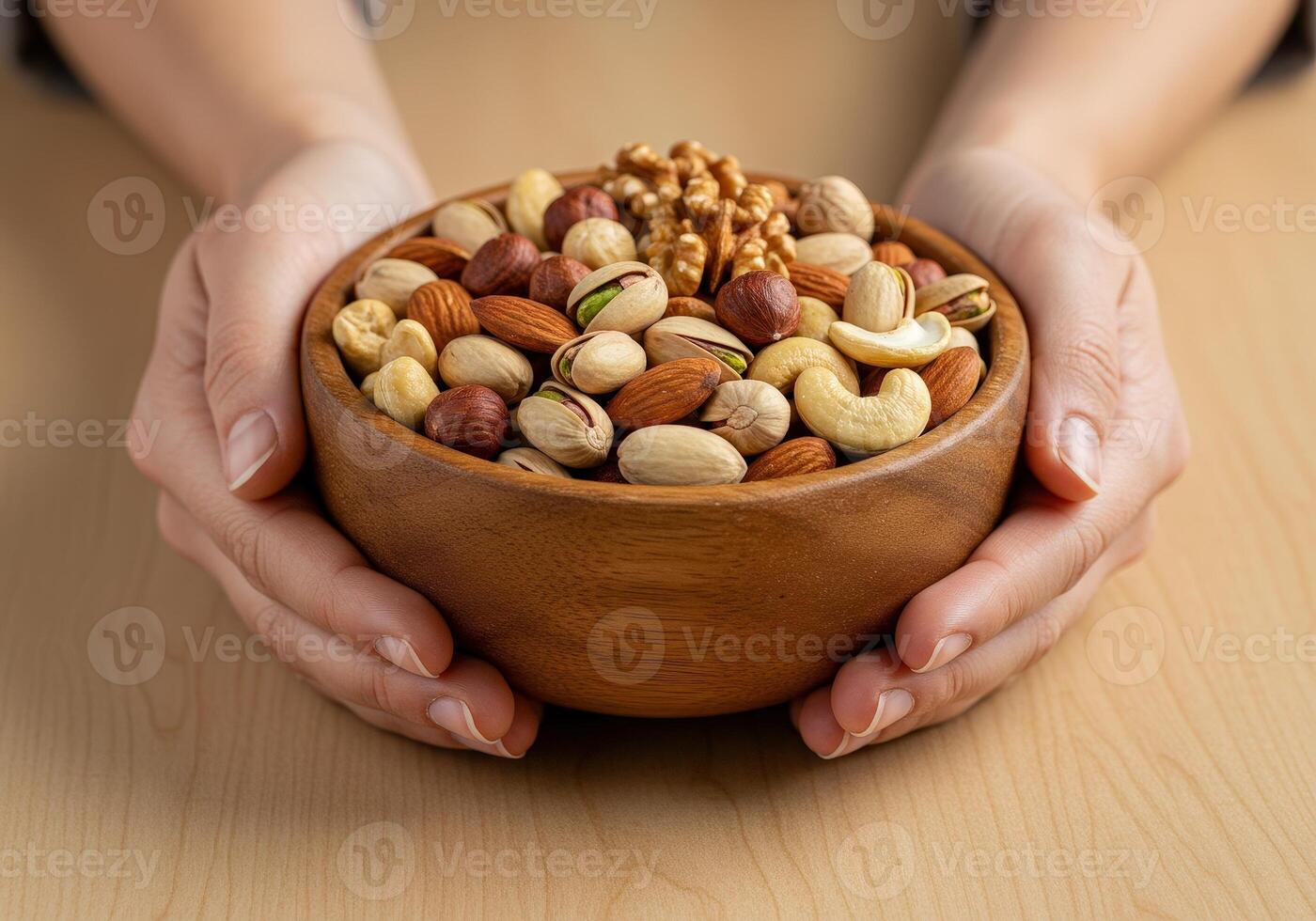 Bowl of assorted nuts held by hands in a cozy setting photo