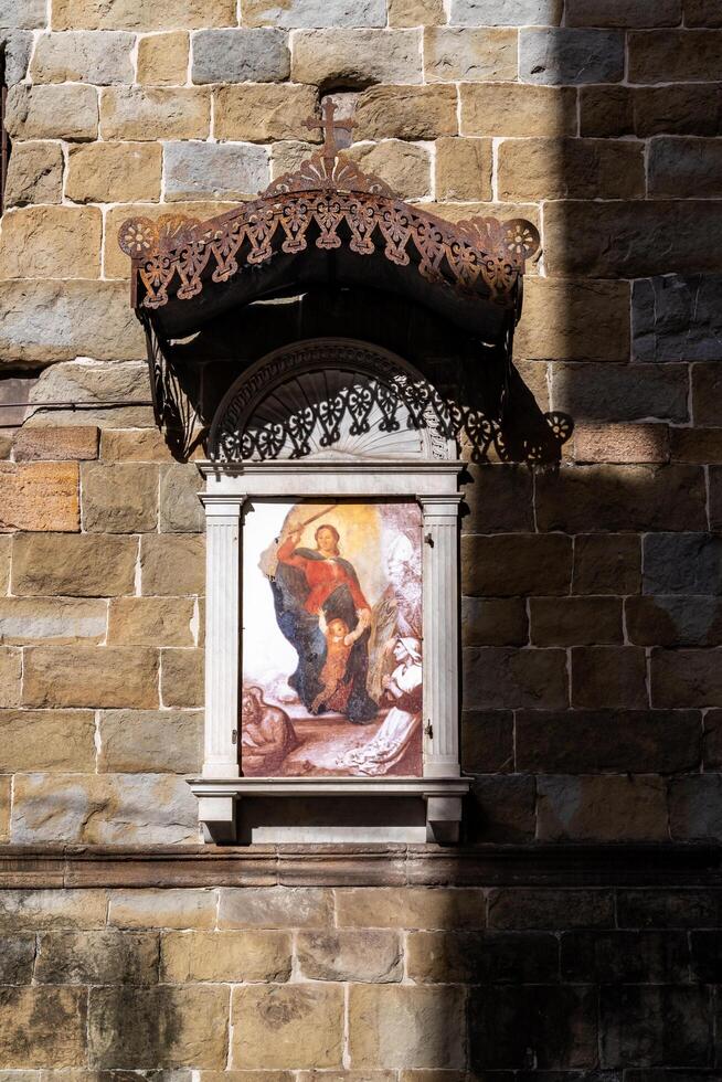 Lucca, Italy-February 16, 2025-vertical photograph of a religious icon on a wall of the Basilica of San Frediano in Lucca during a sunny day photo