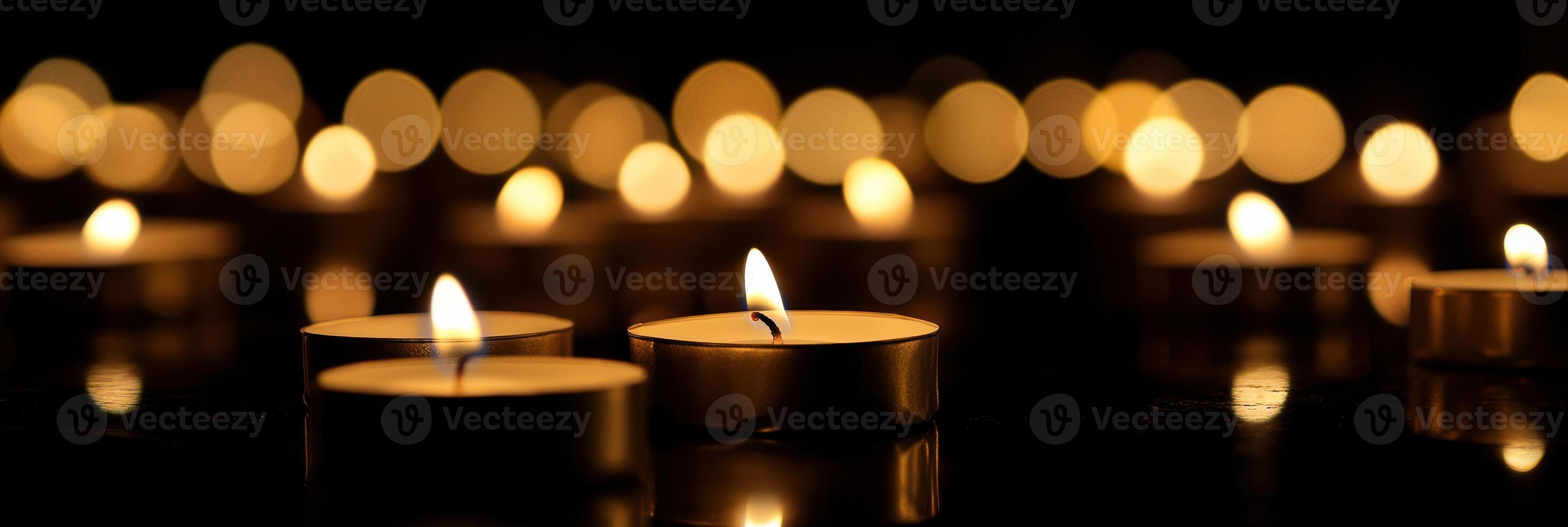 Soft glow of multiple lit candles illuminating a dark background for tranquil atmosphere photo