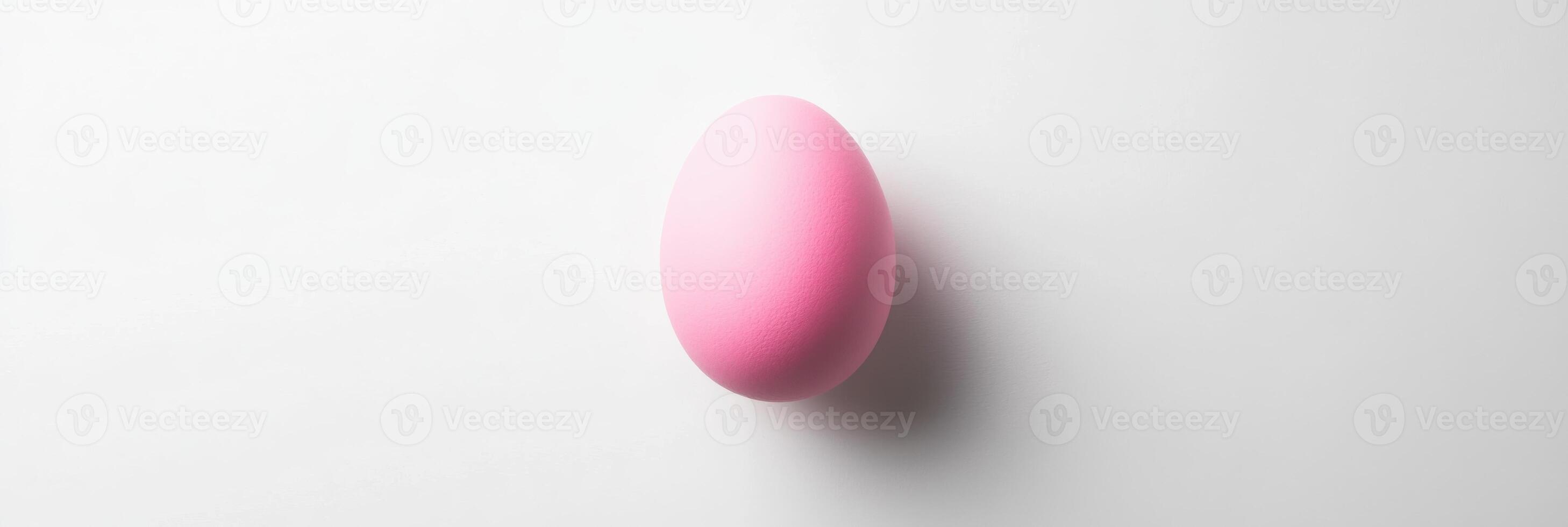 Pink egg on white background highlighting minimalist concept and easter symbolism photo