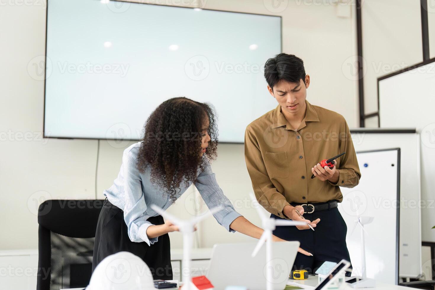 Team Dynamics and Sustainable Solutions. Professionals exploring renewable energy challenges while collaborating effectively. photo
