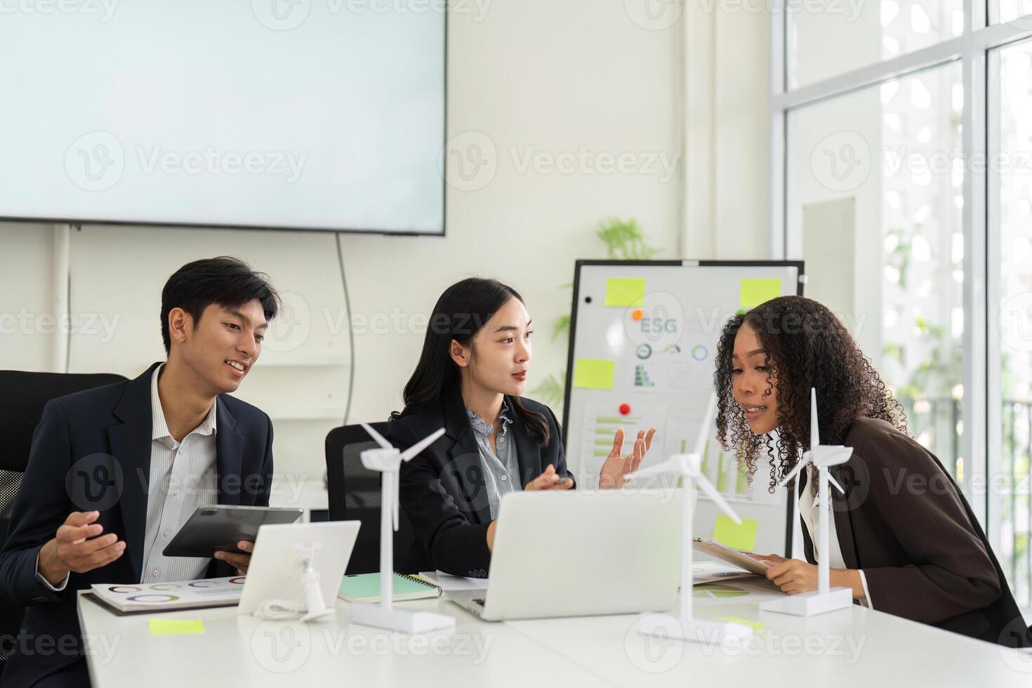 Collaborative ESG Strategy Discussion. Team members evaluate sustainable practices and strategies in a modern office. photo