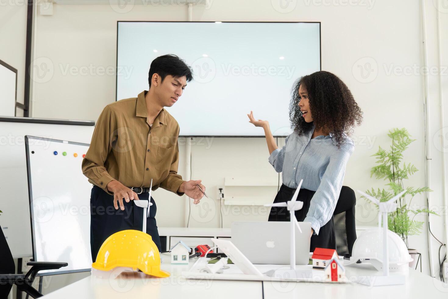 Collaboration and Renewable Energy Planning. Team discussing eco-friendly projects with enthusiasm in a modern office setting. photo
