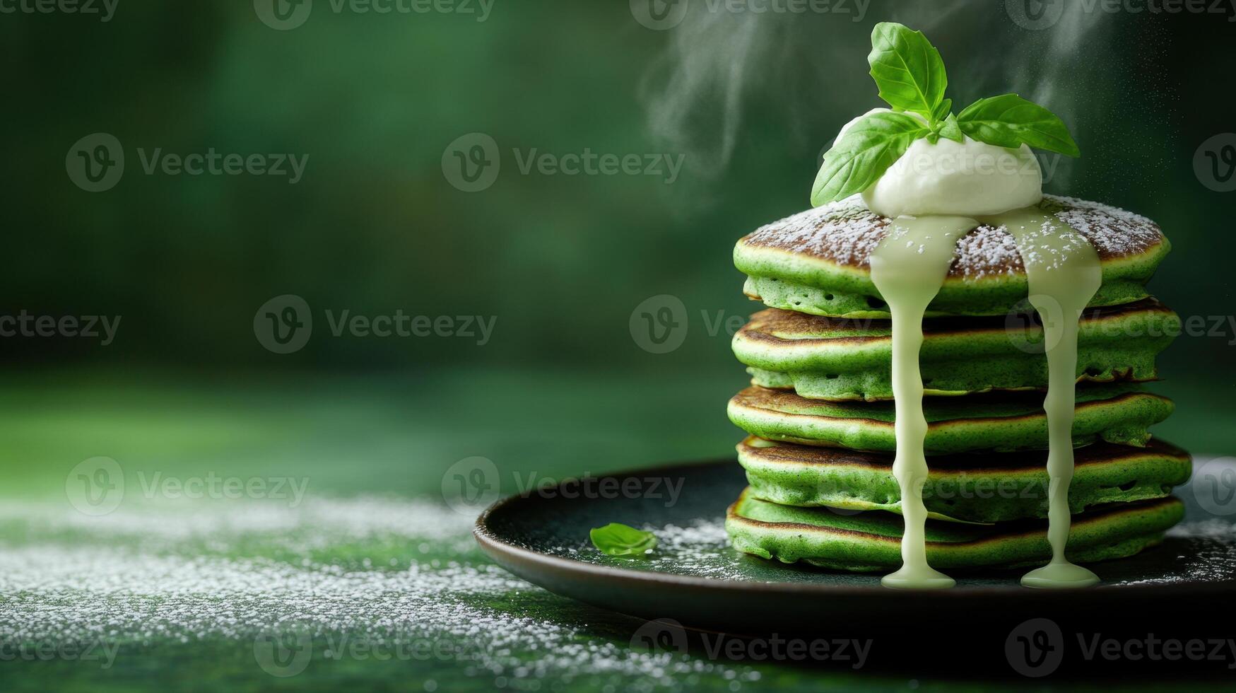 Plate of pancakes dusted with powdered sugar and topped with a green sauce for breakfast or dessert photo
