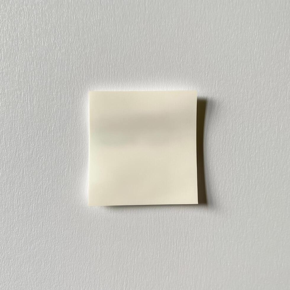 Single Blank Crumpled Sticky Note on Textured Grey White Surface photo