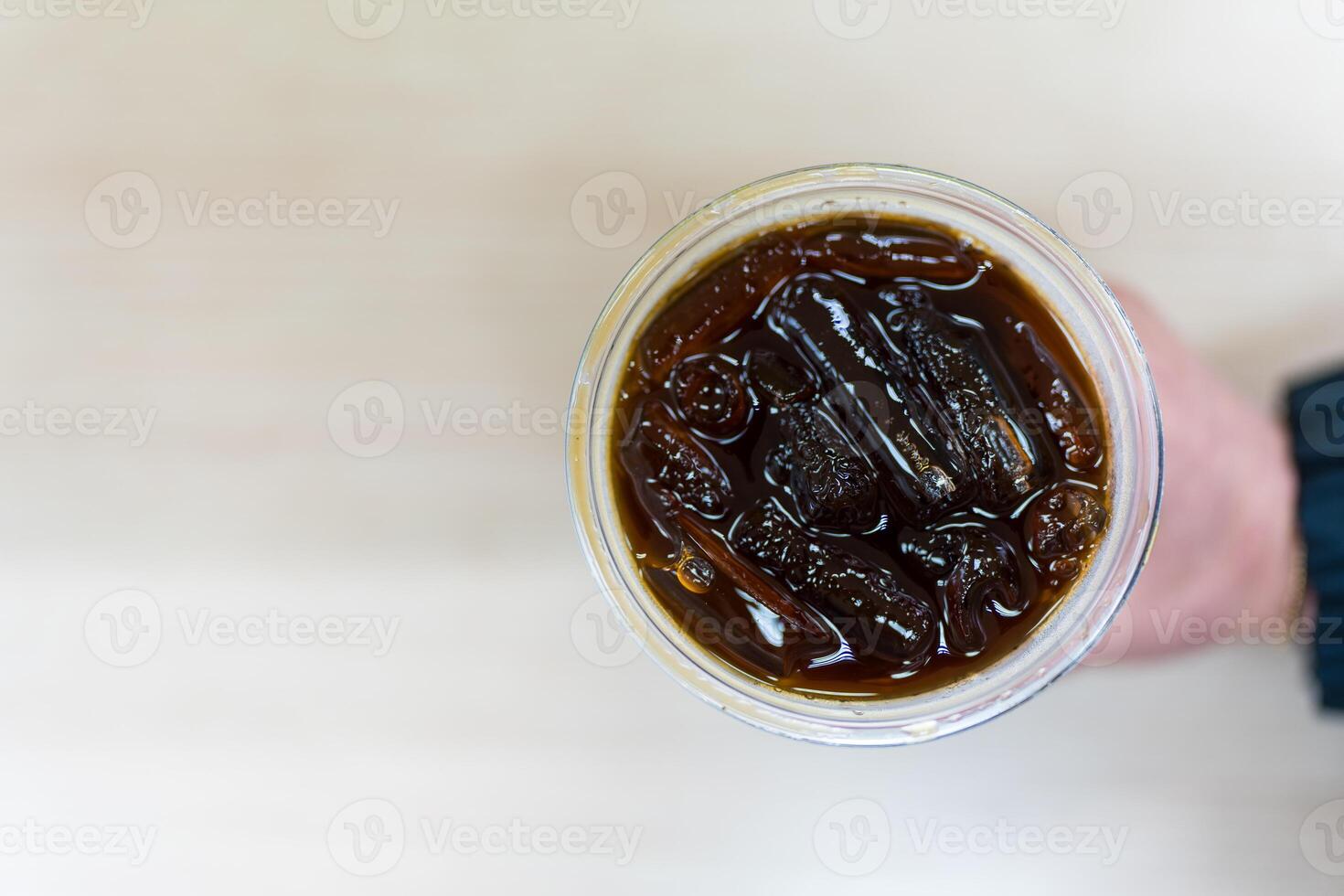 Hand holding a glass of iced Americano photo