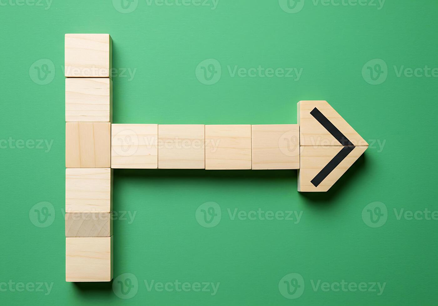 Wooden blocks with arrow pointing to the right on a green background photo