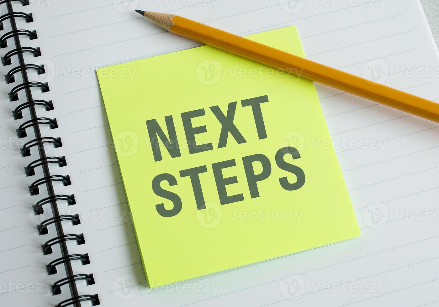 Next steps on a notebook with pencil photo