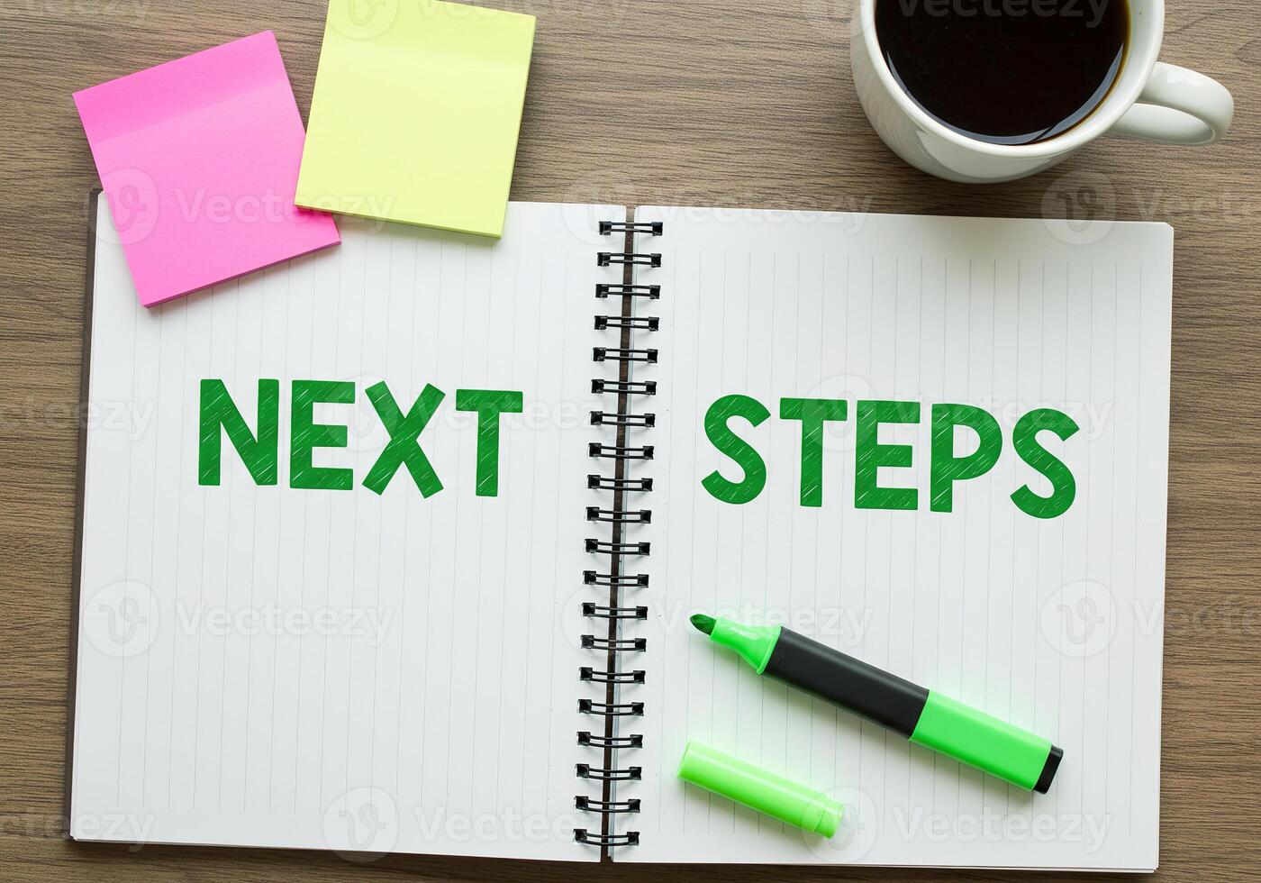 Next steps on notebook with coffee cup and pen photo