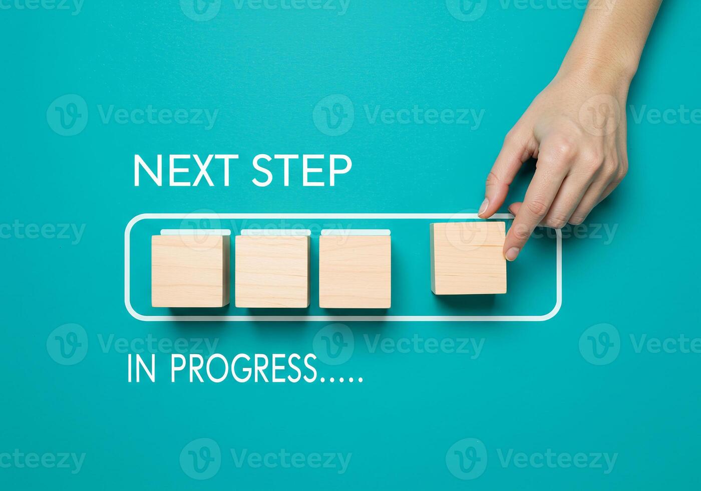 Hand holding wooden blocks next to the word next step in progress photo