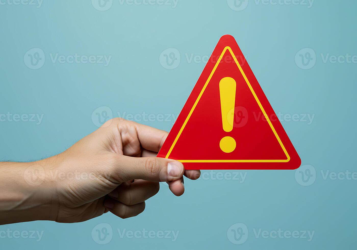A person holding a red warning sign with an exclamation mark photo