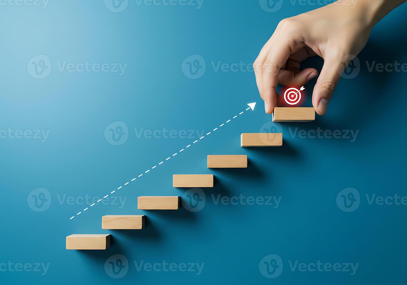 Hand pushing up a stairway with a target on top photo