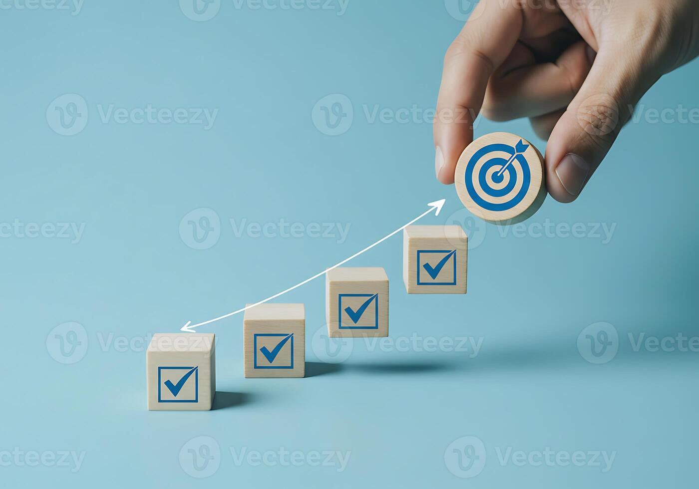 Hand holding wooden blocks with arrows pointing to a target photo