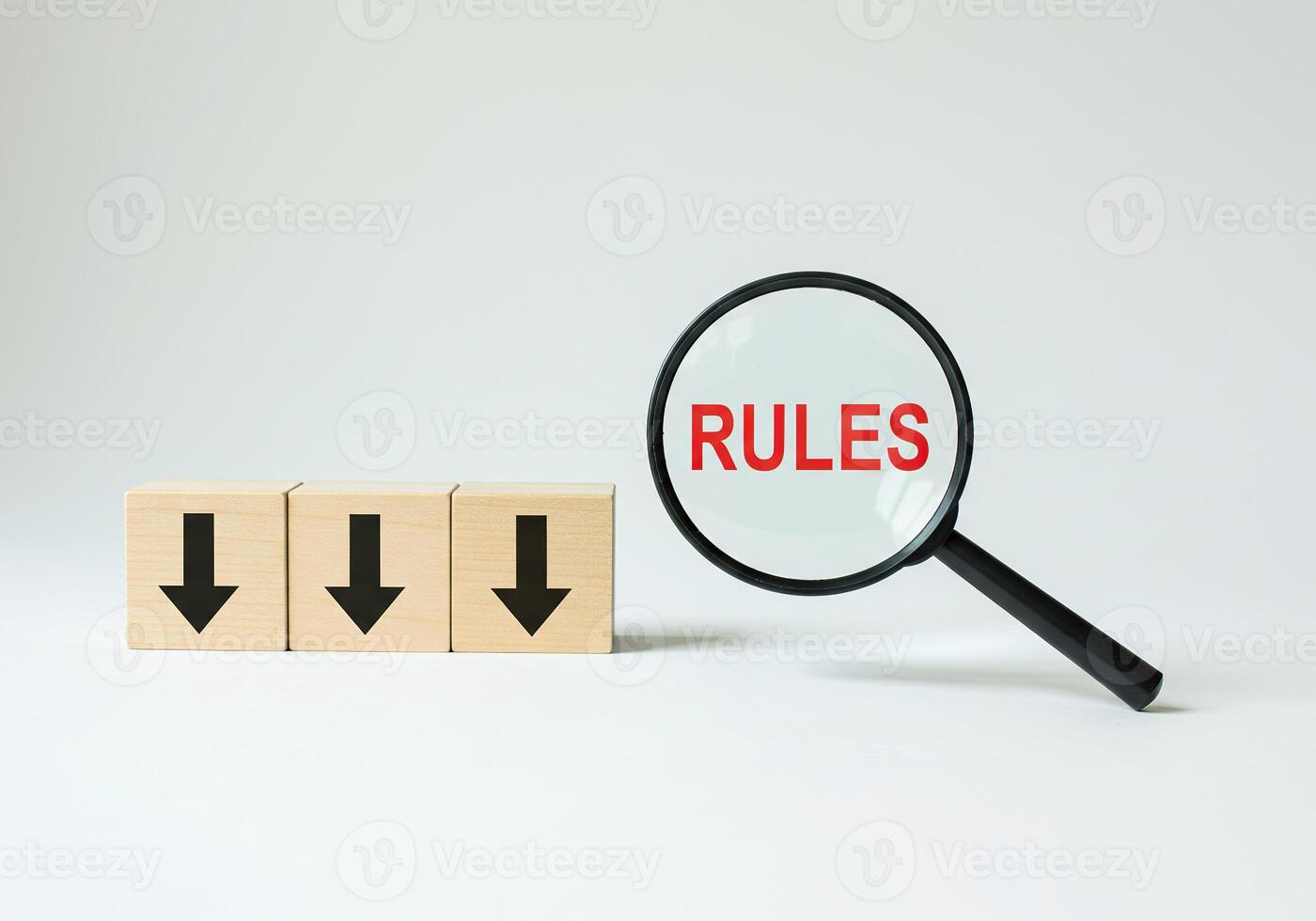 Rules concept with magnifying glass and wooden blocks on white background photo